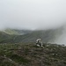 Auf dem namenlosen kleinen Gipfel am Beginn des Bergkamms war die Umgebung noch im Nebel verborgen, Blick Richtung Osten. Hinten im Tal sieht man den See Isavatnet (873 m).