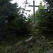 Unscheinbares Gipfelkreuz am höchsten natürlichen Punkt hinter dem Turm