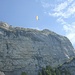 Ein Gleitschirmflieger benutzt die Aufwinde an der Kamorwand zum Steigen