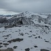 Die Aussicht nach Süden zum Cevedale wird auch immer diesiger, bzw. ziehen leichte Schneeschauer durch. Der Steinmann im Vordergrund ist das einzige Highlight am breiten Gipfel.