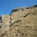 Oberhalb der Felstufe vom Worbi kann man ganz klein das Gipfelkreuz auf dem Nünalphorn (2385m) sehen.