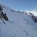 Ich gehe auf dem schneebedeckten Band unter den Felsen in die Nordflanke der Remsspitze.