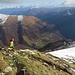 Dalla garitta della Guardia di Confine si scende ripidamente verso l'Alpe Piana con una vista aerea sul paese di Erbonne.