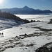 Ripresa la marcia verso la Bocchetta di Chiaro dopo aver messo i ramponi, vista panoramica  verso  la piramide del Legnone che estende ancora la sua ombra sul mare di nubi che coprono il lago.