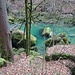 Moosgrüne Steinblöcke im smaragdgrünen Fluss