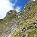 Im Abstieg auf steilem Gras über die Rotechaste SE-Flanke: oben der abschüssige NE-Rücken, unter dem obersten NE-Gratturm der Schrofengraben 