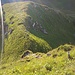 Blick hinab auf die letzte Stufe am Ende des Abstiegs vom Sichelchamm. Rechts im Bild ein weiss-blauer Pfosten, die Stufe wird etwas links umgangen.
