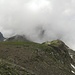 Blick vom Hauptgipfel des Sittliser bei P. 2445 zu P. 2413, wo der Grat durch eine markante Scharte unterbrochen wird. Im Hintergrund im Nebel wäre der Hoch Fulen 2506m