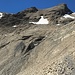 Südflanke des Hüenerhürlis mit dem kurzen instabilen Aufstieg im Bereich des kleinen Felsriegels (T3+). Bildmitte leicht rechts.<br />Die weitere Route führt von rechts her querend unterhalb des Schneefelds in die dunkle gut gestufte Felspartie (T4-) links hoch<br />