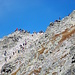 Die Massen versammeln sich auf den beiden Rysy-Gipfeln. Links ist der poln. Rysy (2499m), der höchste Gipfel des Landes. In der Flanke, wo die Leute aufsteigen, sollte man auf evtl. Steinschlag aufpassen.