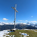 Das Gipfelkreuz vor den Allgäuer Alpen.Ein Gipfelbuch war nicht vorhanden, dafür aber Schreibzeug und eine Sonnenbrille im Behälter.