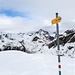 Der Gipfelwegweiser mit dem Piz Julier im Hintergrund. Was nützt einem dieser Wegweiser eigentlich, der einfach wieder zurück weist?