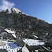 2) Der erste Teil des Südostgrats. Der Aufstieg zum Grat erfolgt an geeigneter Stelle, in etwa bei der Markierung. Danach der Gratrippe bis zur plattigen, riesigen sonnenbeschienenen Barriere folgen. Diese wird rechts umgangen. Der dahinter folgende markante Turm wird dann auf der linken Seite passiert.