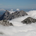 Grintovec - Zoom vom Gipfel auf das Wolkenmeer, aus dem im Osten u. a. folgende Inseln ragen: Turska Gora, Brana, Planjava und Ojstrica.