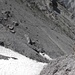 Abstieg in das Val Müschauns. Der Weg führt steile Schotterhalden entlang.