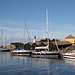 Unterwegs auf Christiansø - Soeben sind wir mit der Fähre aus Gudhjem (Bornholm) angekommen und blicken nun über den Südteil des Hafenbeckens zur Nachbarinsel Frederiksø. Dort dürften u. a. die Kanonenbootsschuppen zu sehen sein.