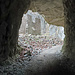 Blick aus einem Felstunnel zu einer Ruine im Rotzloch. 