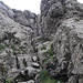 Statt am Drahtseil über die glitschigen Felsen, finden sich links davon trockene Griffe und Tritte.