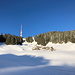 Im Aufstieg zum Grünten - Über den schneebedeckten Hang geht der Blick zu den Sendeanlagen am südwestlichen Nebengipfel.
