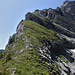 Blick vom Sattel ca. 2115m zur NNW-Flanke, über die die Normal- und Abstiegsroute führt: oben rechts der Gipfelturm und in der Mitte der obere SE-Grat, darunter der abzukletternde Felsriegel (II)