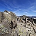 Am Gipfel der Südlichen Pflunspitze, markiert durch eine Art Grenzstein, mit Blick auf den weiteren Gratverlauf.