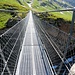 <b>Lo raggiungo grazie ad un sentiero, assicurato per un lungo tratto da nuove catene, da usare come corrimano. Il ponte metallico, lungo 65 m, scavalca l’orrido ad un’altezza massima di 40 m sul Rein da Sumvitg. <br />Lo attraverso in silenzio, accompagnato dai miei sonanti passi e dallo scroscio dell’acqua nella gola. Non perdo l’occasione per registrare un video che mi permetterà, al computer, di osservare meglio sia il manufatto che i dintorni, e non solo il punto d’appoggio degli scarponi sulle grate… </b>