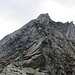 Vor mir sind zwei junge Klettersteigbegeher unterwegs; rechts etwas oberhalb von ihnen sieht man die senkrechte Felswand mit der C-Passage.
