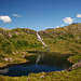 Der See liegt hinter dem Wall und speist den Wasserfall