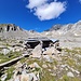 <b>Dopo questa diroccata stalla inizia un sentiero, segnalato in bianco/rosso, che scende fino all’ultimo tornante della strada del passo, a 2410 m. </b>