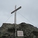 Unter dem Kreuz ist eine Tafel mit einem altbekannten Spruch angebracht.