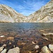 Le limpide acque increspate del Lago Ledù dove si specchiano le montagne circostanti. In fondo si vede l’intaglio della Bocchetta del Ledù da cui si scende in Val Garzelli, dalla quale siamo venuti. (foto Fabio)