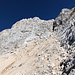 Im Aufstieg zum Jôf di Montasio - Nach einer Pause geht's gleich über das Geröllfeld und dann vor der Felsflanke vorbei in Richtung Forca Verde. Westlich (links) davon befindet sich die Scala Pipan.