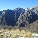 Arrivando all’Alpe Busarasca, a sinistra si vedono tutte le montagne che chiudono la Val Pogallo; in centro foto i selvaggi versanti che scendono dalla Corona di Ghina; la freccia indica la posizione dove sorge il Bivacco Bocchetta di Campo. 