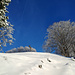 Rückblick zum Gipfelkreuz unter blauem Himmel