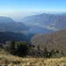 Dal Palanzone, vista verso il ramo di Como dell’omonimo lago; sullo sfondo il Monte Rosa e la foschia che copre la pianura. Il Rifugio Riella si trova oltre gli abeti visibili in primo piano.