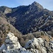 Ometto in vetta alla Cima di Noga quota 1517 mt e vista su Cima di Fiorina e Torrione di Valsolda. 