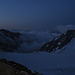 blaue Stunde im Aufstieg am Finsteraarhorn, das Rhonetal in Wolken