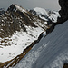 Unverspurt: Aussicht vom abwechselnd über Gras, Schnee und leichte Felsen führenden Kaiseregg NE-Grat zurück zum schroffen Stieregrat und hinüber zur noch homogen eingeschneiten Widdergalm WSW-Flanke, ebenfalls ein lohnendes Abfahrtsziel
