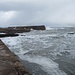 Die tosende Nordsee klatscht an die Hafenmauer von Cove Harbour