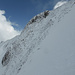 Abfahrt über die Balmi N-Flanke auf griffigem Schnee zwischen abgeblasenen Schrofen hindurch. Oben in der Mitte der Gipfel, links der N-Grat (Aufstieg), rechts der SW-Grat (Abfahrt)