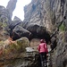 Hier führt eine Metalltreppe rechts hinauf in eine kleine, schmale Schlucht. 