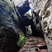 Dieser Weg führt in eine Schlucht hinauf, in die einst riesige Brocken gestürzt sind, die heute eine Abfolge niedriger Höhlen bilden. Durch diese Höhlen führen die ca. 150 Jahre alten Steinstufen hinauf.