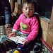 Das kleine Mädchen im Lodge in Najing Dingma hält das Malheft fest in seinen Händchen