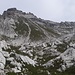 Anderntags, wieder zurück auf der Forcolotta, eröffnet sich wenige Meter dahinter dieser Blick auf den Anstieg zur Cima Ceda Orientale. Man zielt am besten zunächst auf die rechte der beiden von oben herabziehenden Schurren zu (großer Steinmann am unteren Ende), um dann weglos über den Grashang hinauf nach links zu einer Art Scharte zu steigen.