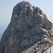 Blick vom Benzimeni Vrh zum Bobotov Kuk, der Abstieg geht über die obere Felsen und die schräge Platte und quert danach schräg nach links unten (von der Sonne beschienen), die letzten Meter dann direkt ab