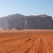 Tag 5 (24.10.) - وادي رم (Wādī Rum):<br /><br />Vom Dorfrand fuhren wir zunächst auf rotem Sand leicht ansteigend immer südwärts durch den ganzen Nationalpark in Richtung Saudi-Arabien. Zunächst peilten unser Fahrer und Führer den Sandstein-Doppelgipfel an den wir westlich auf der rechten Seite passierten. Der vordere Berggipfel ist der 1392m hohe جبل الخزعلي (Jabal al Khaz‘alī), der Hintere der mit 1497m hohe جبل كوش خشح (Jabal Kūsh Khashaḩ).