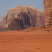 Tag 5 (24.10.) - وادي رم (Wādī Rum):<br /><br />Das wuchtige, unzugängliche Sandsteinmassif vom جبل أم عشرين (Jabal ’Umm ‘Ishrīn) aus Süden gesehen. Der 1745m hohe Hauptgipfel, Jordaniens dritthöchster Berg, ist aus dieser Perspektive nicht zu sehen.