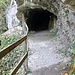 Tunneleingang mit Lichtschalter, in der Vergrößerung ist der Pfeil am Felsen gut zu sehen