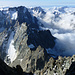 Gipfelaussicht nach S: vorne der Tiefblick über die wilde S-Wand Richtung Col des Avalanches, darüber u.a. Pic Coolidge und Pic de la Temple im zerrissenen Grat zur L'Ailefroide, in der Mitte Les Bans mit dahinter Le Sirac, rechts die Têtes und Pic de Mal Cros, und am Horizont La Mer Méditerranée...