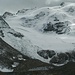 Blick von der Bergstation auf die Route (während einem feinen Gulasch...;-)). Der Schotterweg ist immer noch verschneit, die Route bei näherem Hinsehen erkennbar und der Gipfel wartet auf seine nächsten Besteiger.